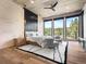Stunning bedroom with floor-to-ceiling windows showcasing mountain views, a ceiling fan and light hardwood floors at 34089 Woodland Dr, Evergreen, CO 80439