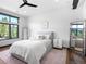 Cozy bedroom featuring plush bedding, hardwood floors, large window, and modern decor at 34089 Woodland Dr, Evergreen, CO 80439