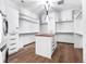 Walk-in closet featuring custom shelving, a center island, washer/dryer hook ups, and hardwood floors at 34089 Woodland Dr, Evergreen, CO 80439