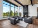 Bright living room features floor-to-ceiling windows, a stone fireplace, and mountain views at 34089 Woodland Dr, Evergreen, CO 80439