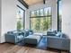 Bright living room boasts large windows with scenic views, contemporary furniture, and hardwood floors at 34089 Woodland Dr, Evergreen, CO 80439