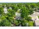 Aerial view of a home with a spacious backyard, patio, and lush trees in a residential neighborhood at 5167 S Pearl St, Littleton, CO 80121
