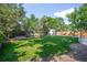 Well-maintained backyard with a large grassy area, bordered by a wooden fence and mature trees at 5167 S Pearl St, Littleton, CO 80121