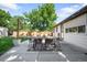 Backyard patio with dining area, string lights, and a view of the well-manicured lawn and lush trees at 5167 S Pearl St, Littleton, CO 80121