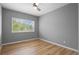 Empty bedroom with light gray paint, wood floor and a large window at 14300 Waterside Ln # E3, Broomfield, CO 80023