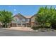 Townhomes with gray siding, stone accents, and two car garages at 14300 Waterside Ln # E3, Broomfield, CO 80023