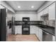 Well-lit kitchen with stainless steel refrigerator, black appliances, and white cabinets at 14300 Waterside Ln # E3, Broomfield, CO 80023