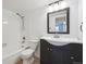 Well-lit bathroom with modern vanity, tiled shower-tub combo, and white walls at 12037 E Harvard Ave # 104, Aurora, CO 80014
