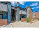 Charming condo exterior with blue siding, brick accents, and well-maintained landscaping under a bright sky at 12037 E Harvard Ave # 104, Aurora, CO 80014