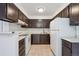 Well-lit kitchen showcasing dark wood cabinets, white appliances, and tiled floors at 12037 E Harvard Ave # 104, Aurora, CO 80014