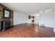 Open living room with hardwood floors, a stone fireplace, and views into the adjacent kitchen at 12037 E Harvard Ave # 104, Aurora, CO 80014