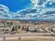 Expansive view featuring a street intersection, a building with a parking lot, and a scenic background under a bright sky at 10941 Parker Vista Rd, Parker, CO 80138