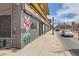 Street view showing building exterior with painted brick, mural, and sidewalk at 1425 N Washington St # 104, Denver, CO 80203