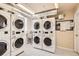 Functional laundry room with multiple washers and dryers, a utility sink, and tile flooring for convenience at 1425 N Washington St # 104, Denver, CO 80203