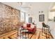 Inviting living room featuring exposed brick, hardwood floors, a stylish sofa, and ample natural light at 1425 N Washington St # 104, Denver, CO 80203
