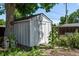 Backyard shed with trees and shrubs that has a concrete paver path to it at 4654 Bryant St, Denver, CO 80211