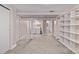 A finished basement with carpet flooring and an open layout, featuring a laundry area and shelving at 4654 Bryant St, Denver, CO 80211