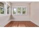 Bright bedroom features hardwood floors and three windows with natural light at 4654 Bryant St, Denver, CO 80211