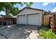 View of a detached two car garage with access from a concrete driveway and surrounded by greenery at 4654 Bryant St, Denver, CO 80211