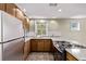 Kitchen features updated appliances, wood cabinets, granite counters and tile backsplash at 4654 Bryant St, Denver, CO 80211