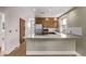 Bright kitchen with granite countertop island, tiled backsplash, stainless appliances, and wood cabinets at 4654 Bryant St, Denver, CO 80211