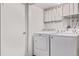 A laundry room with a white washer and dryer and a door leading outside at 4654 Bryant St, Denver, CO 80211