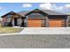 Stunning home featuring a spacious driveway and a modern two-car garage with stylish wood doors and stone accents at 740 W County Road 10E, Berthoud, CO 80513