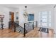 Inviting foyer featuring hardwood floors, modern light fixture, and staircase with black railings for an open design at 740 W County Road 10E, Berthoud, CO 80513