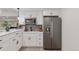 Modern kitchen with stainless steel appliances, white cabinets, and a gray tile backsplash at 740 W County Road 10E, Berthoud, CO 80513