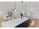 Open kitchen and living area with a spacious island, modern lighting, and seamless flow at 740 W County Road 10E, Berthoud, CO 80513