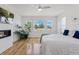 Bright bedroom with hardwood floors, a modern fireplace, and large windows offering ample natural light at 740 W County Road 10E, Berthoud, CO 80513