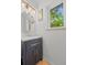 Bathroom with a dark vanity, round mirror, overhead lighting, and a window offering natural light at 1409 Quince Ave, Boulder, CO 80304