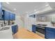 Bright kitchen with white countertops, wood floors, stainless steel appliances, and vibrant blue cabinetry at 1409 Quince Ave, Boulder, CO 80304
