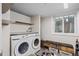 Well-equipped laundry room with washer, dryer, shelving, and a storage bench at 1409 Quince Ave, Boulder, CO 80304