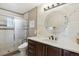 Bright bathroom features granite counters, shower with sliding glass door and round mirror at 18027 E Ida Dr, Centennial, CO 80015