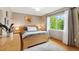 Cozy bedroom featuring neutral walls, wood floors, area rug and a large window with natural light at 18027 E Ida Dr, Centennial, CO 80015