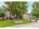 Well-maintained front yard with green lawn, mature trees, decorative rock, and a two-car garage home at 18027 E Ida Dr, Centennial, CO 80015