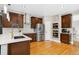Modern kitchen with stainless steel appliances, dark wood cabinets, and hardwood flooring at 18027 E Ida Dr, Centennial, CO 80015