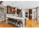 Beautiful kitchen with stainless steel appliances, dark wood cabinets, island, and hardwood flooring at 18027 E Ida Dr, Centennial, CO 80015