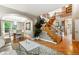Open-concept living room with hardwood floors, staircase, archway, and neutral decor at 18027 E Ida Dr, Centennial, CO 80015