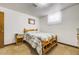 Bedroom with wooden frame bed and side table is well-lit with natural light from the window at 7651 Shoshone St, Denver, CO 80221
