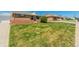 Home with spacious front yard featuring healthy lawn, a sidewalk, and brick accents at 7651 Shoshone St, Denver, CO 80221