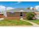 Charming brick home featuring a well-maintained lawn and inviting walkway at 7651 Shoshone St, Denver, CO 80221