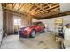 Spacious garage features exposed beams, a red SUV, and ample storage space at 7651 Shoshone St, Denver, CO 80221