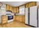 Well-lit kitchen with wooden cabinets and updated appliances for modern living at 7651 Shoshone St, Denver, CO 80221