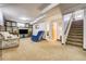Spacious basement living room with built-in shelving and staircase to the main floor at 7651 Shoshone St, Denver, CO 80221
