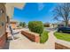 Inviting porch view with a rocking chair, brick accents, and lush greenery at 7651 Shoshone St, Denver, CO 80221