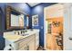 Stylish bathroom featuring a vanity with white counters, framed mirror, and views to other rooms at 2117 S Troy Way, Aurora, CO 80014