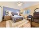 Comfortable bedroom with a ceiling fan, shuttered windows, a cozy chair, and wood-look floors at 2117 S Troy Way, Aurora, CO 80014