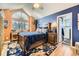 Charming bedroom featuring a large window, a ceiling fan, wood-look floors, and adjacent bathroom at 2117 S Troy Way, Aurora, CO 80014
